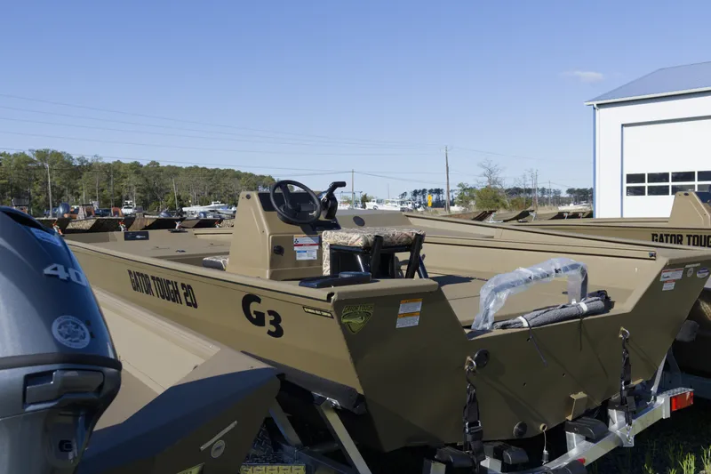 Slide: The Image of 2026 G3 Gator Tough 20 CC boat displayed outdoors near a building. - 8