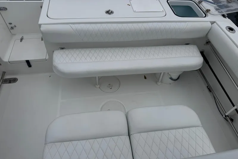 Slide: The Image of 2011 Sea Hunt Gamefish 27 boat interior with white cushioned seating. - 10