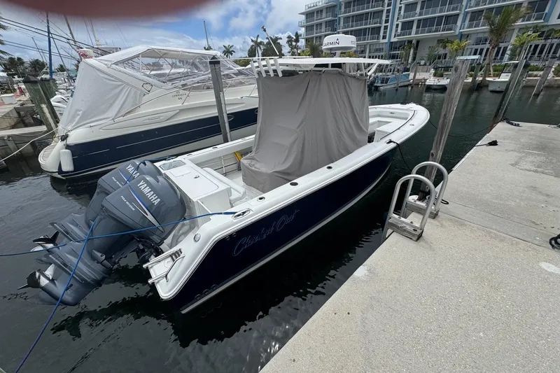 Slide: The Image of 2011 Sea Hunt Gamefish 27 boat docked with Yamaha engines, marina background. - 2