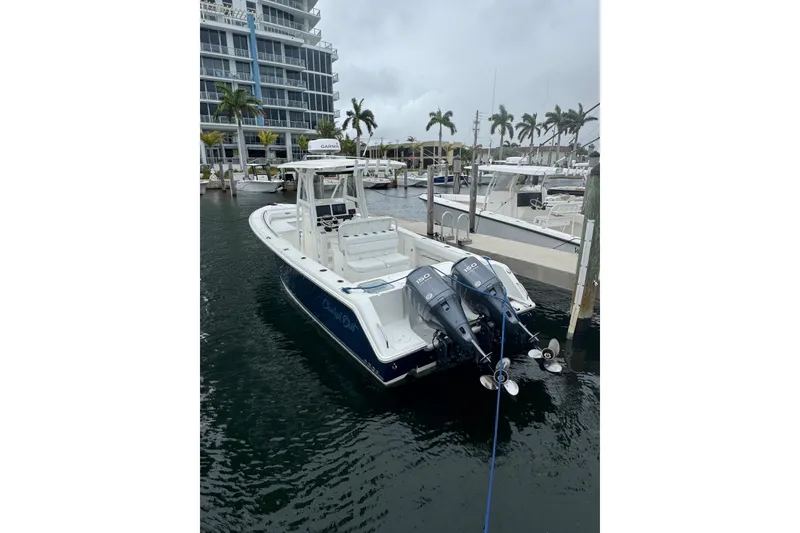 Slide: The Image of 2011 Sea Hunt Gamefish 27 boat docked, featuring dual outboard motors and forward seating. - 3