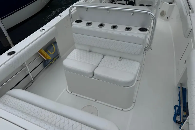 Slide: The Image of 2011 Sea Hunt Gamefish 27 boat interior with white cushioned seating and rod holders. - 9