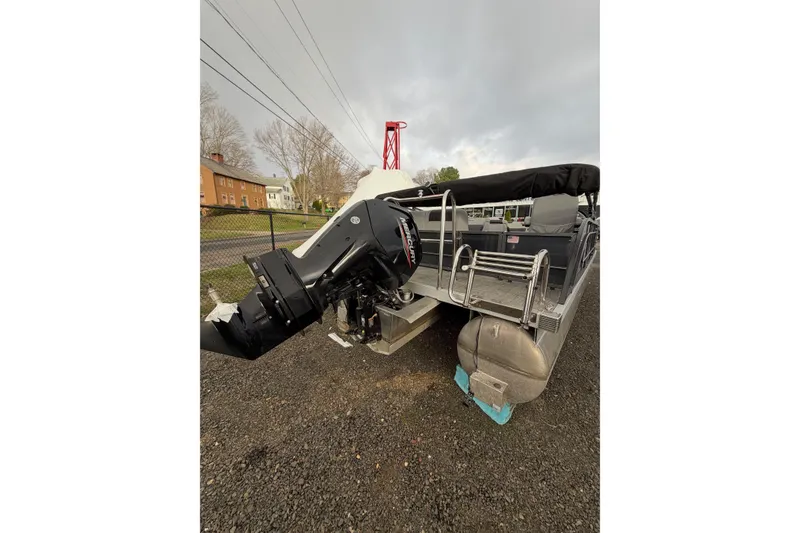 Slide: The Image of 2024 Massimo Marine P-22 Limited pontoon boat with powerful outboard motor, parked outdoors. - 3