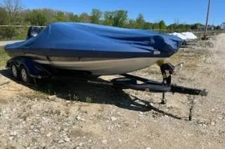Slide: The Image of 2004 Ranger 210 Reata boat covered, on trailer, parked on gravel lot. - 4