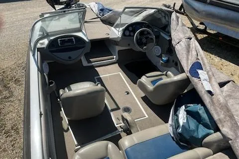 Slide: The Image of 2004 Ranger 210 Reata boat interior with seating and dashboard, partially covered. - 5