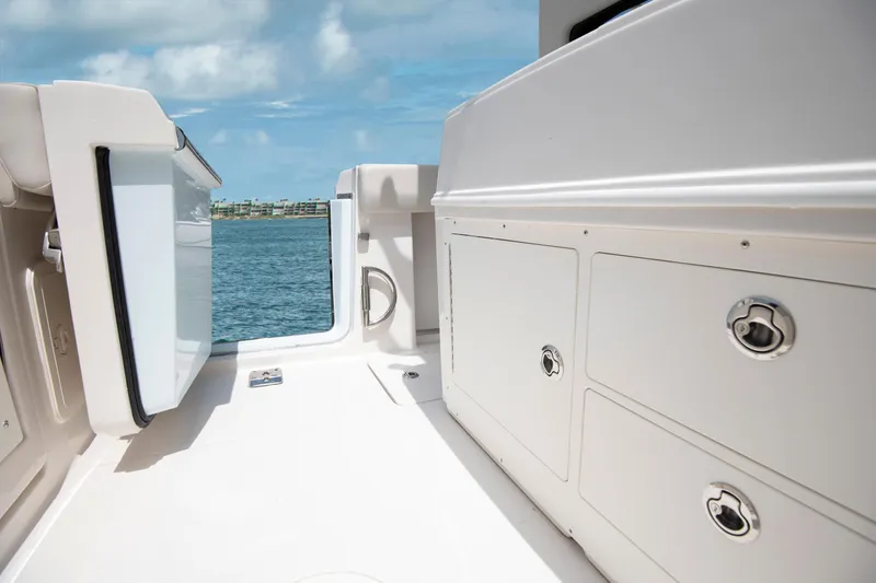 Slide: The Image of Sailfish 272 CC 2027 boat interior with storage compartments, open hatch, and ocean view. - 15