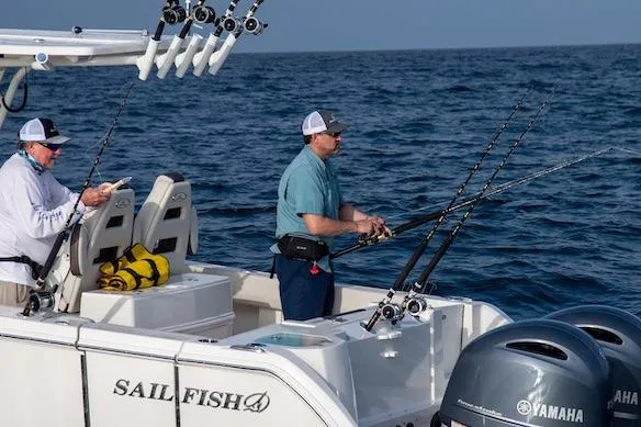 Slide: The Image of Two people fishing on a 2027 Sailfish 272 CC boat in the ocean. - 4