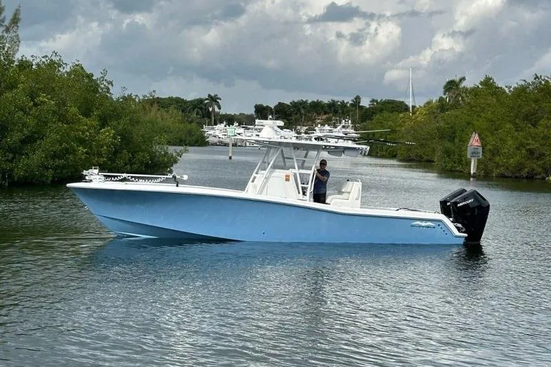 The Image of 2021 Invincible 33 Open Fisherman boat on a calm waterway, surrounded by greenery. - 0