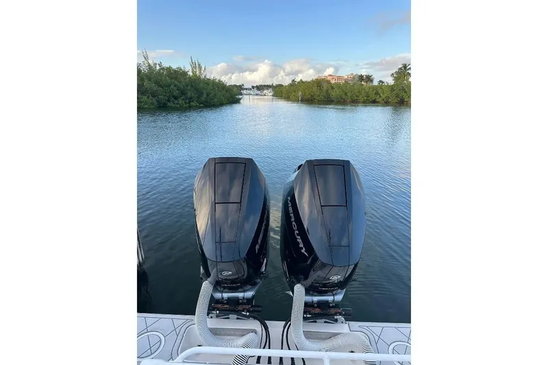 Slide: The Image of Twin Mercury engines on a 2021 Invincible 33 Open Fisherman boat in a serene waterway. - 10