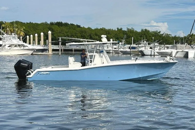 Slide: The Image of 2021 Invincible 33 Open Fisherman boat on calm water near marina. - 2