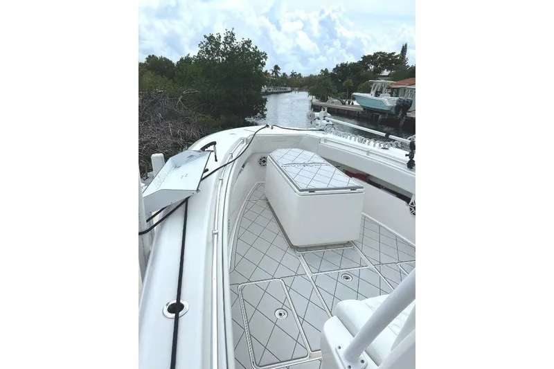 Slide: The Image of 2021 Invincible 33 Open Fisherman boat on a serene waterway, showcasing spacious deck and seating. - 5
