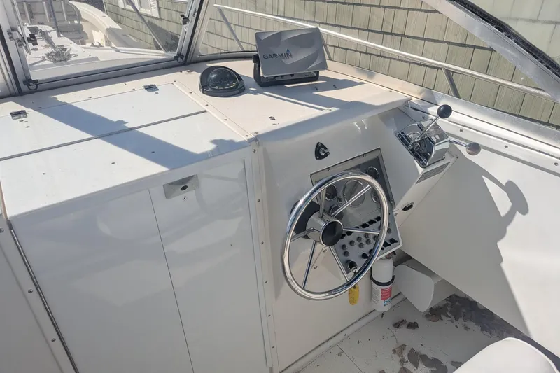 Slide: The Image of 1993 Shamrock 220 Walkaround boat helm with steering wheel, Garmin GPS, and control panel. - 12