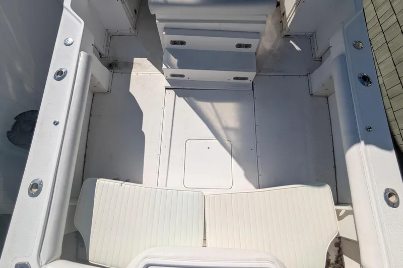 Slide: The Image of 1993 Shamrock 220 Walkaround boat interior with white seating and storage compartments. - 16