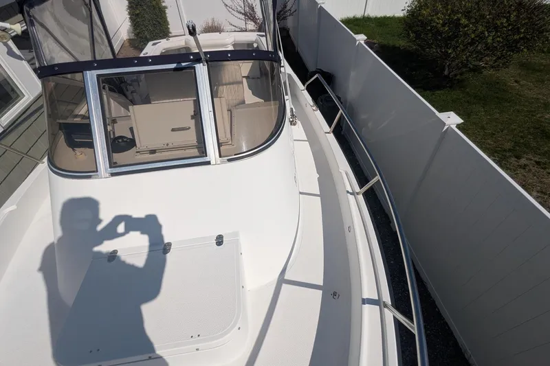 Slide: The Image of 1993 Shamrock 220 Walkaround boat, white deck, enclosed cabin, outdoor setting. - 19