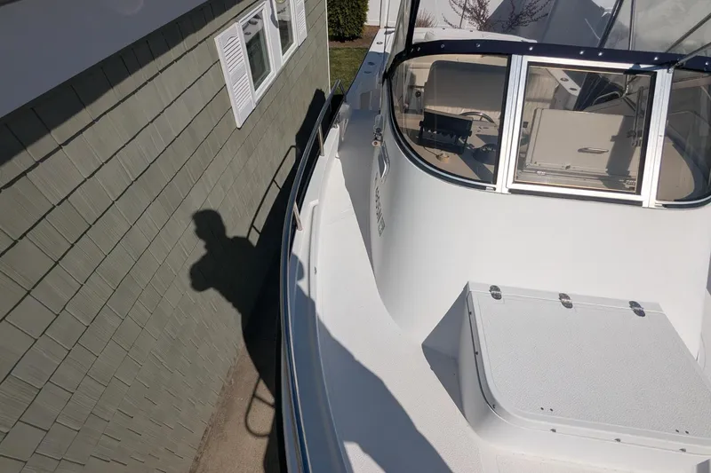 Slide: The Image of 1993 Shamrock 220 Walkaround boat docked beside a green shingled building. - 20