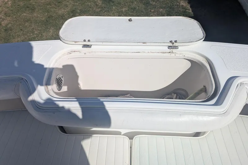 Slide: The Image of Open storage compartment on a 1993 Shamrock 220 Walkaround boat, with visible ropes inside. - 26