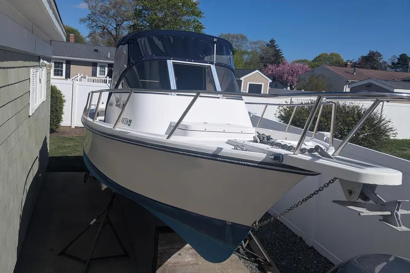 Slide: The Image of 1993 Shamrock 220 Walkaround boat on trailer, parked beside a house in a suburban neighborhood. - 3