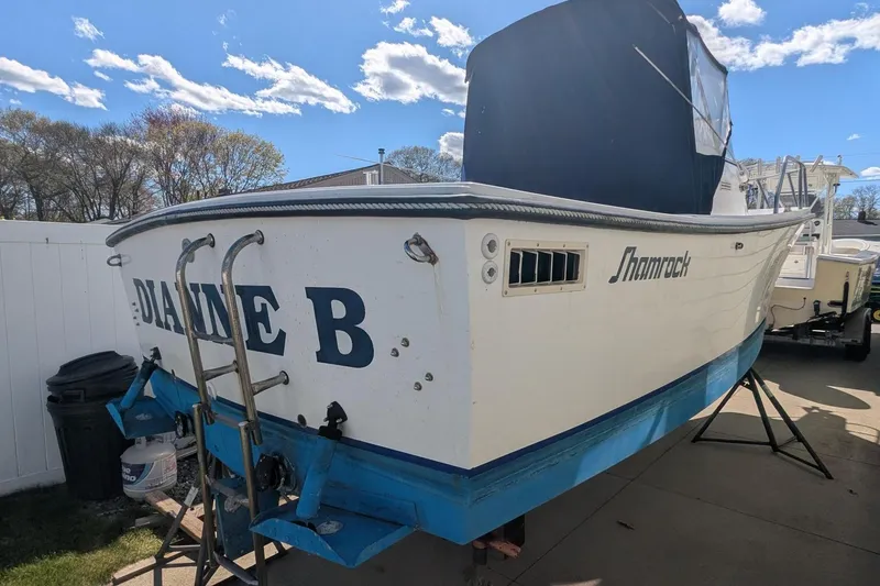 Slide: The Image of 1993 Shamrock 220 Walkaround boat on trailer, named "Dianne B," under a clear blue sky. - 4