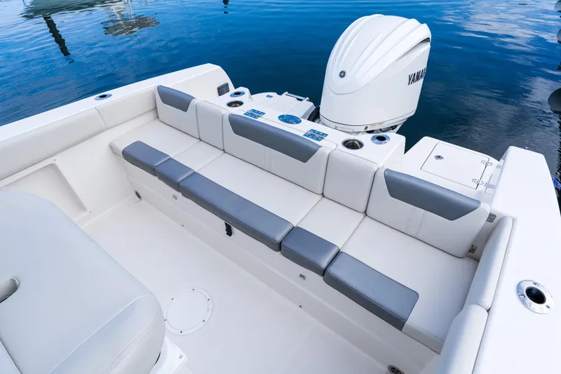 Slide: The Image of 2027 Sailfish 232 CC boat with cushioned seating and Yamaha outboard motor on calm water. - 15