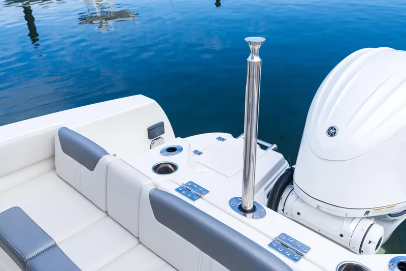 Slide: The Image of Sailfish 232 CC 2027 boat interior with motor and seating, docked on calm water. - 18