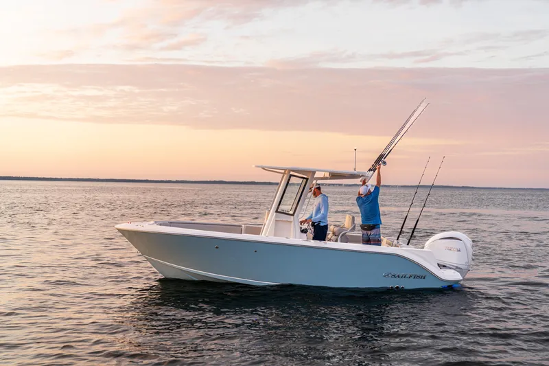 Slide: The Image of 2027 Sailfish 232 CC boat on calm water at sunset, two people fishing. - 2