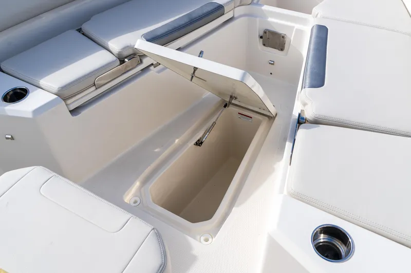 Slide: The Image of 2027 Sailfish 232 CC boat interior with open storage compartment and cushioned seating. - 6