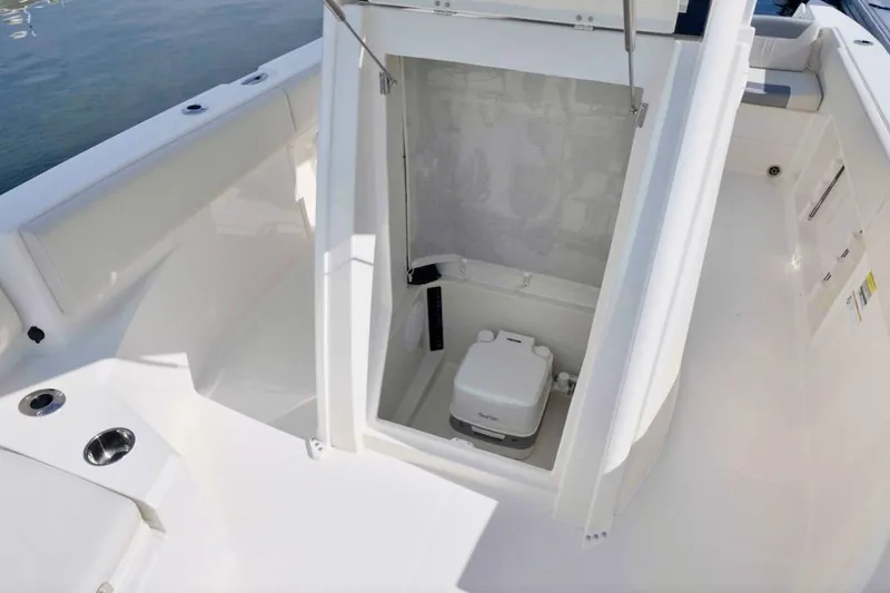 Slide: The Image of 2027 Sailfish 232 CC boat interior with open compartment and portable toilet. - 9