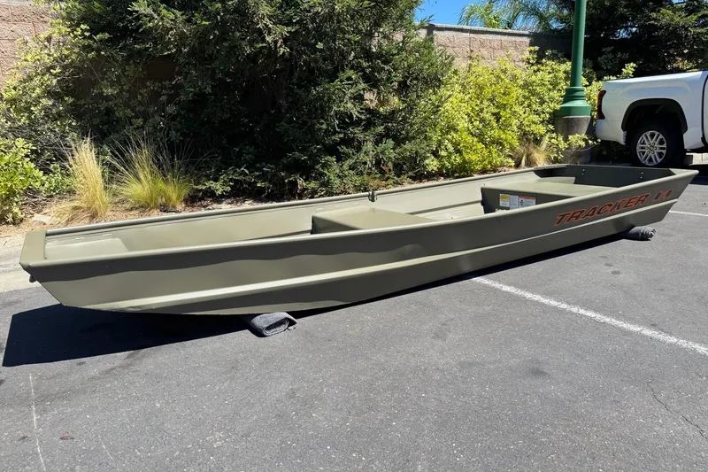 Slide: The Image of 2026 Tracker Grizzly 14 Jon boat parked outdoors on pavement. - 2