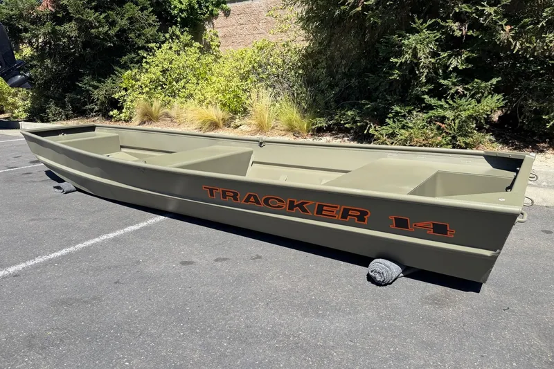 Slide: The Image of 2026 Tracker Grizzly 14 Jon boat in a parking lot, showcasing its sturdy design. - 3