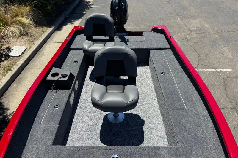 Slide: The Image of 2026 Tracker Super Guide V-16 T boat interior with gray seating and red trim. - 10