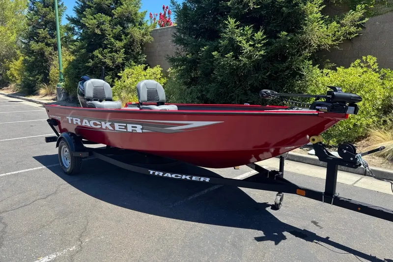 Slide: The Image of Red 2026 Tracker Super Guide V-16 T boat on trailer, parked outdoors. - 3