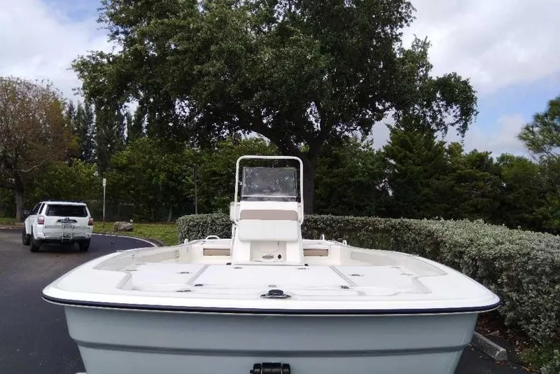 Slide: The Image of 2026 Mako Pro Skiff 19 CC boat parked outdoors with trees in the background. - 94