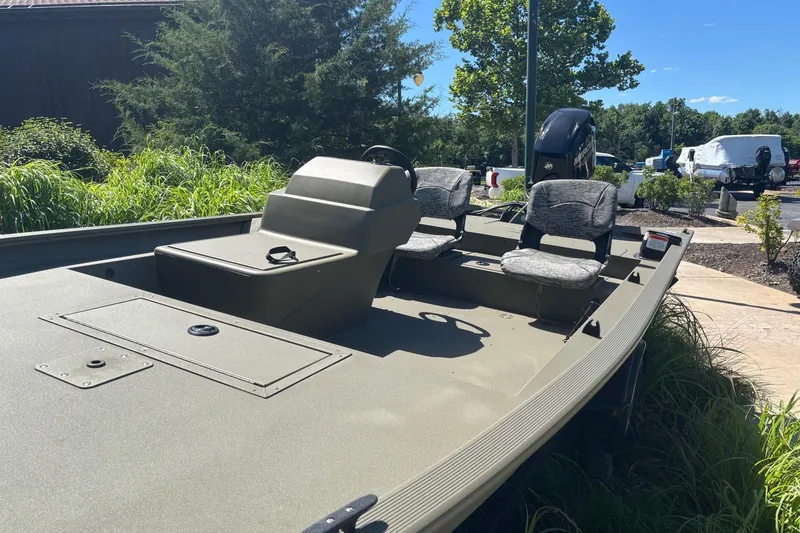 Slide: The Image of 2026 Tracker Grizzly 1754 SC boat with seating, parked outdoors on a sunny day. - 2