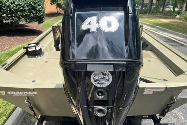 Slide: The Image of 2024 Tracker Grizzly 1648 SC boat with a 40 HP outboard motor, parked outdoors. - 3