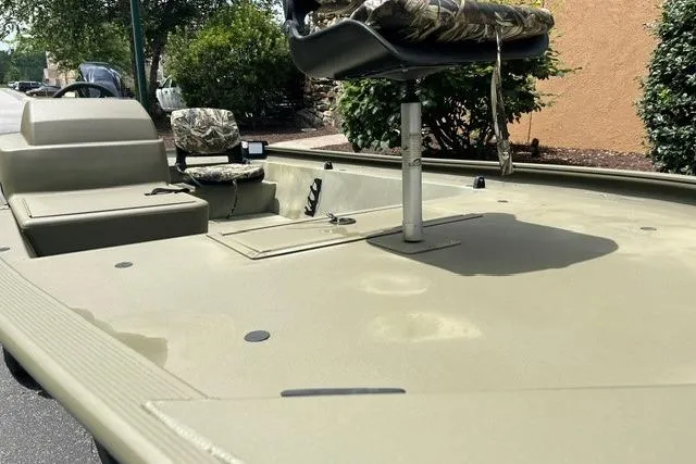Slide: The Image of 2024 Tracker Grizzly 1648 SC boat interior with camo seats and spacious deck. - 5