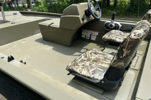 Slide: The Image of 2024 Tracker Grizzly 1648 SC boat interior with camouflage seats and steering console. - 9