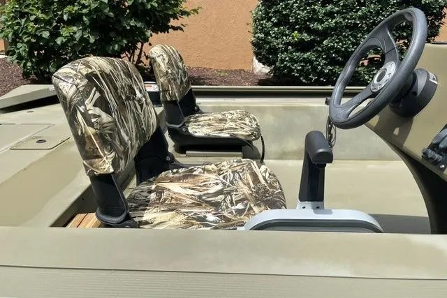 Slide: The Image of 2024 Tracker Grizzly 1648 SC boat interior with camo seats and steering wheel. - 6