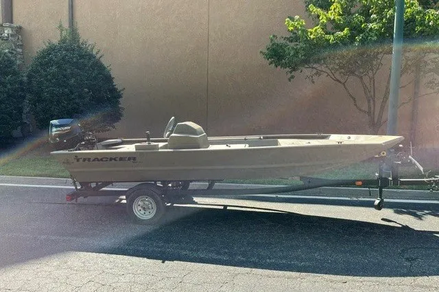 The Image of 2024 Tracker Grizzly 1648 SC boat on trailer, parked outdoors in sunlight. - 0