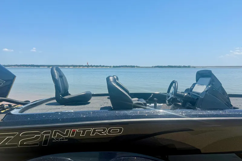 Slide: The Image of 2026 Nitro Z21 XL Pro boat on a serene lake under a clear blue sky. - 5