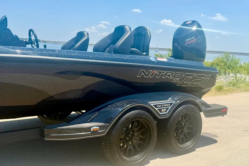 Slide: The Image of 2026 Nitro Z21 XL Pro boat on trailer by a lake, featuring sleek design and dual wheels. - 8