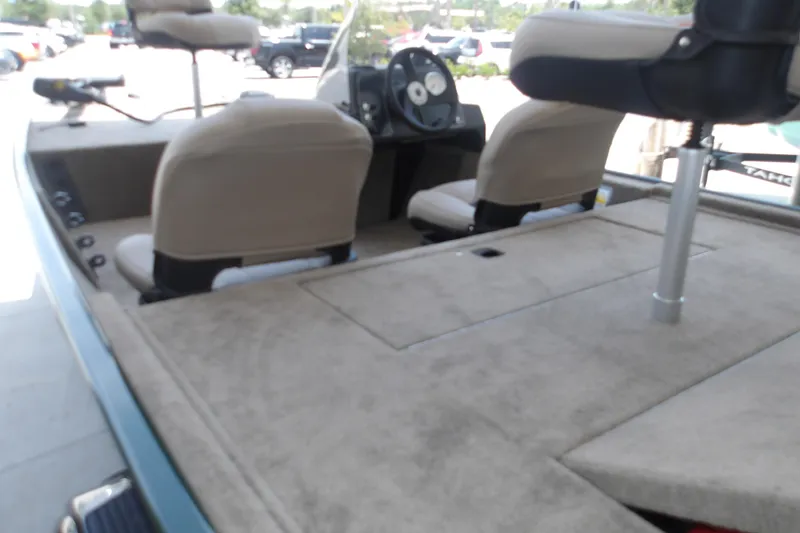 Slide: The Image of 2026 Tracker Bass Tracker Classic Limited boat interior with beige seating and steering console. - 14