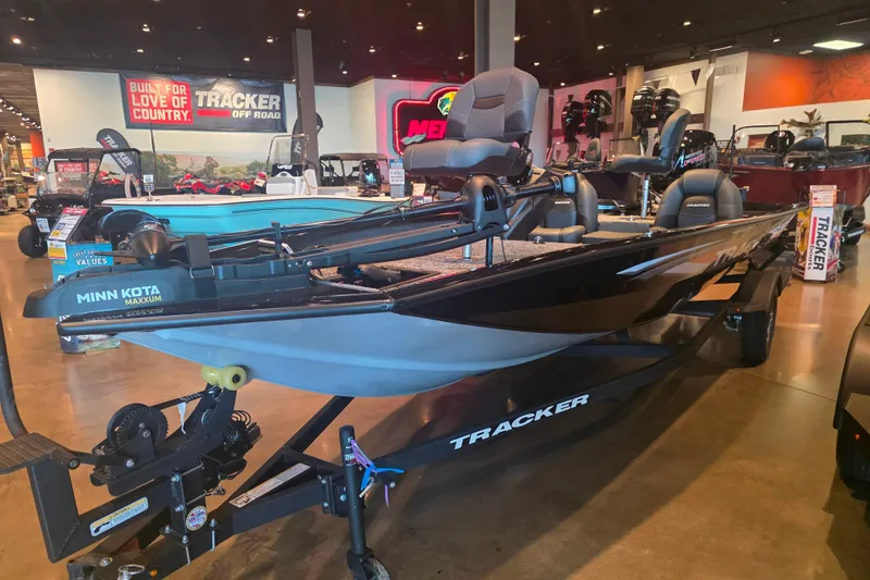 Slide: The Image of 2026 Tracker Pro Team 190 boat displayed in showroom with Minn Kota Maxxum motor. - 2