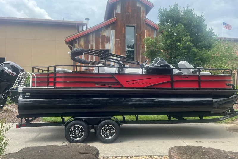 The Image of 2026 Ranger 220F pontoon boat with Mercury engine, parked outdoors near rustic building. - 0