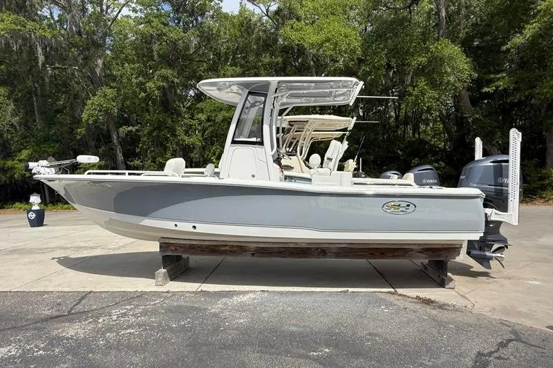 The Image of 2018 Sea Hunt BX 25 FS boat on display, surrounded by trees. - 1