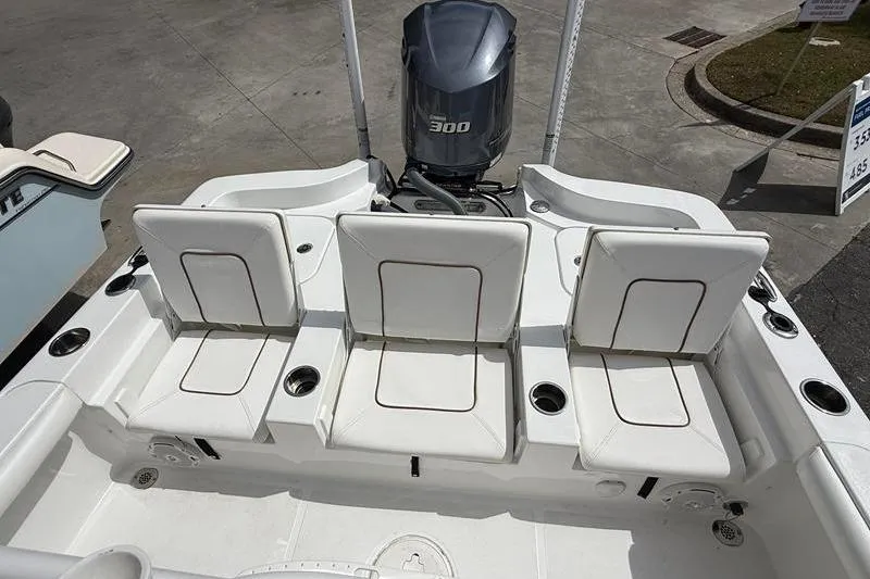 Slide: The Image of 2018 Sea Hunt BX 25 FS boat with three white cushioned seats and a 300 HP engine. - 10