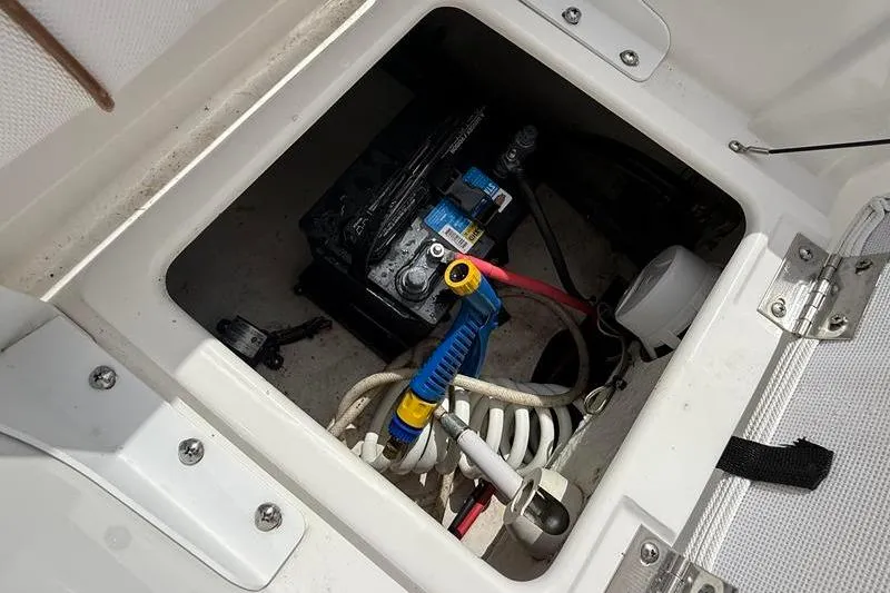 Slide: The Image of 2018 Sea Hunt BX 25 FS boat battery compartment with wiring and equipment. - 13