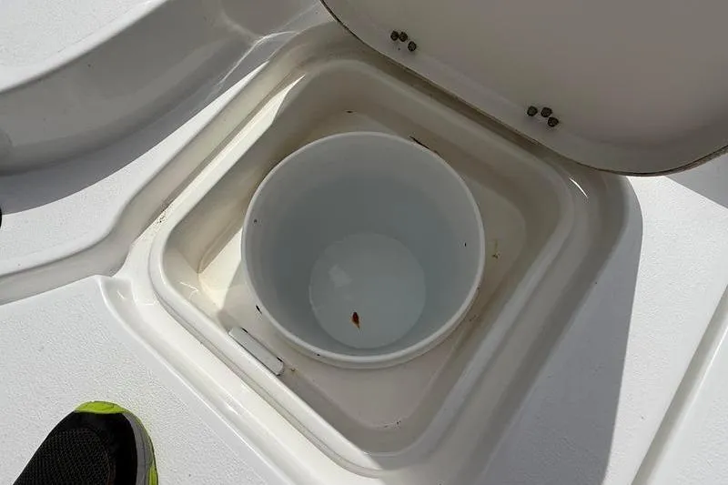 Slide: The Image of Open storage compartment on 2018 Sea Hunt BX 25 FS boat with a bucket inside. - 17