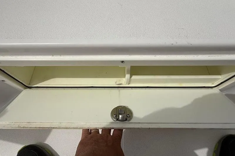 Slide: The Image of Storage compartment on a 2018 Sea Hunt BX 25 FS boat, open with latch visible. - 38