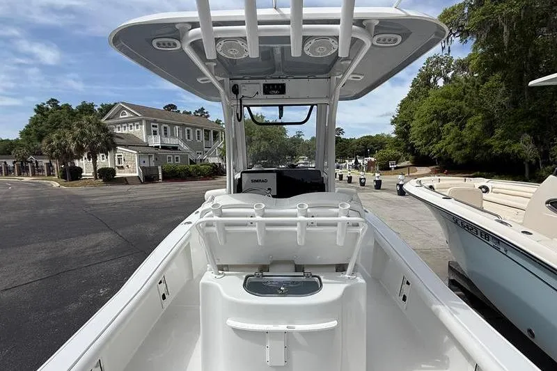 Slide: The Image of 2018 Sea Hunt BX 25 FS boat interior with console and seating, parked near residential area. - 9