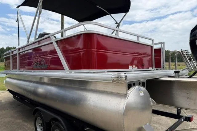 The Image of 2026 Sun Tracker Party Barge 22 RF DLX pontoon boat with red exterior and canopy. - 0