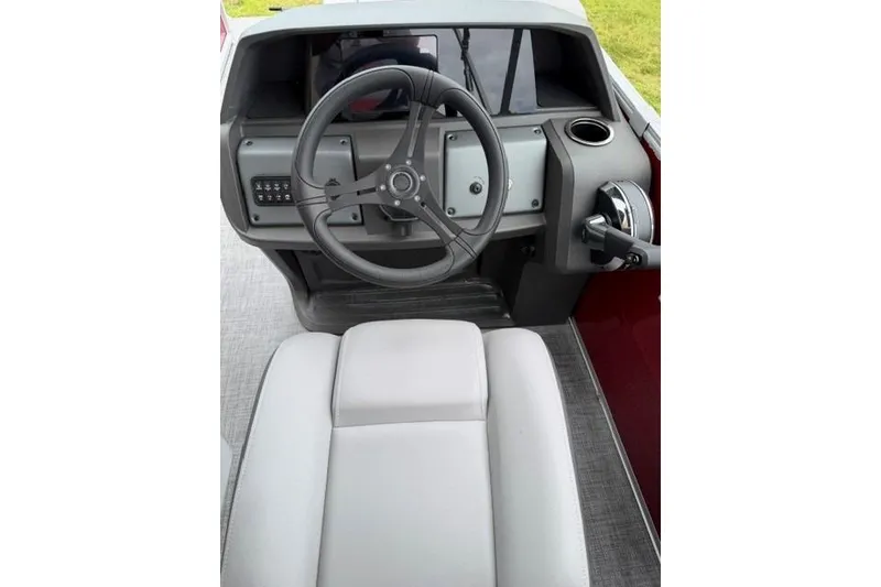 Slide: The Image of 2026 Sun Tracker Party Barge 22 RF DLX helm with steering wheel and controls. - 11